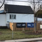 Hamilton homeowner standing in front of newly converted legal basement suite with Gateway Group signage
