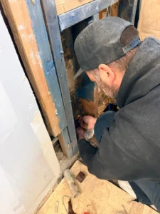 Open wall during Hamilton home renovation revealing knob-and-tube wiring in pre-1960 property requiring remediation before work can continue